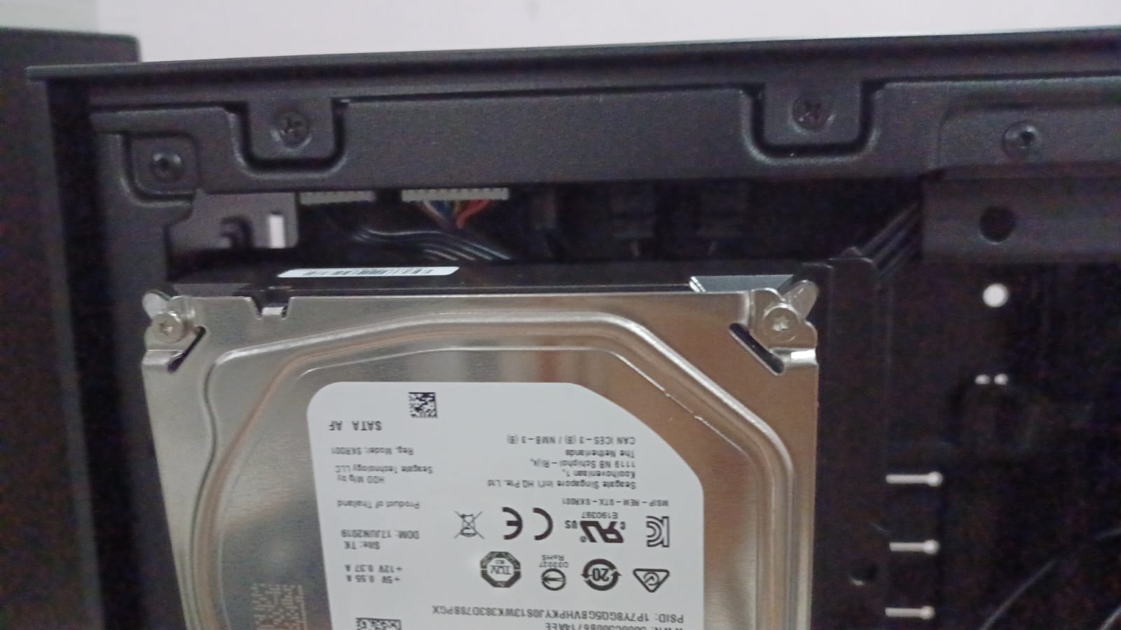 A closeup of a 3.5 inch hard drive mounted just beneath the front I/O panel.